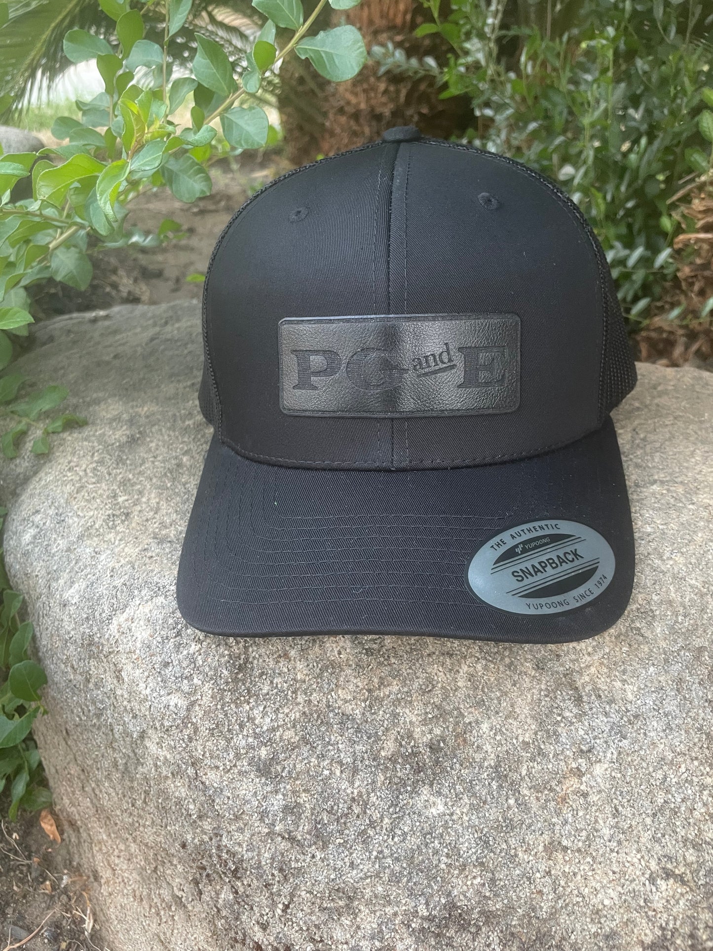 Yupoong Black Out Logo